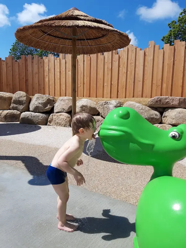 kind speelt in de speeltuin van het zwembad op de camping in Normandië